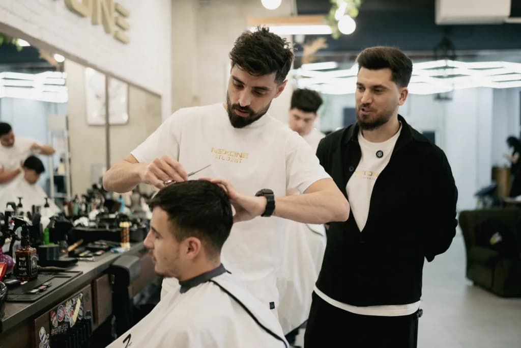 Frizer Nexone tunzând un client în salon
